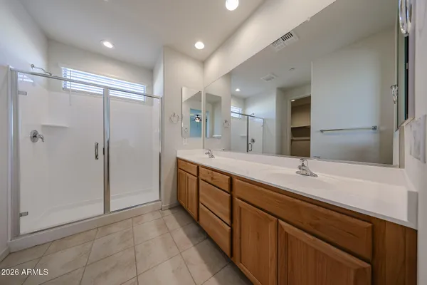 a spacious bathroom with a mirror a shower and vanity