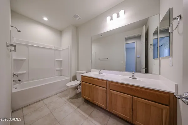 a bathroom with a double vanity sink toilet mirror and bathtub