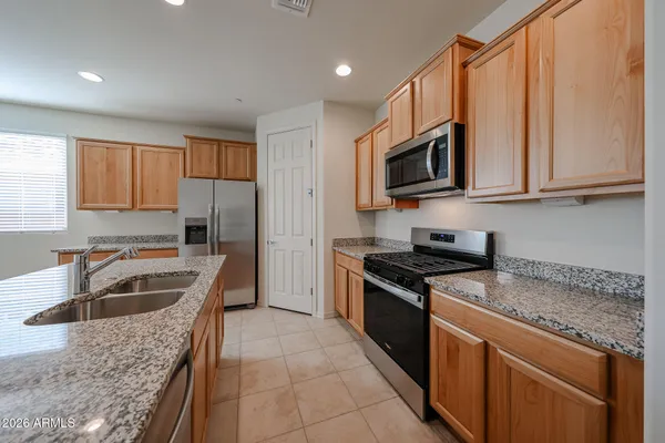 a kitchen with granite countertop stainless steel appliances a stove sink and microwave