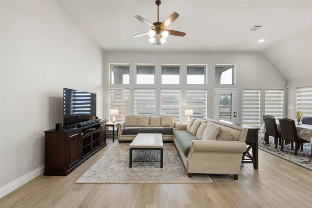 a living room with furniture and a flat screen tv with wooden floor