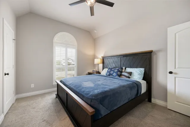 a bed sitting in a spacious bedroom next to a window
