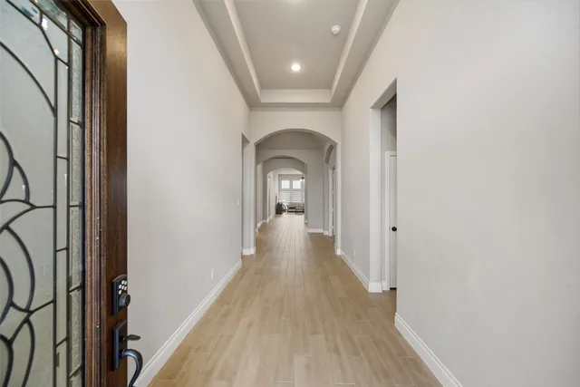 a view of a hallway with wooden floor and staircase