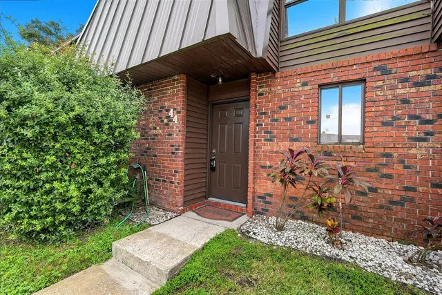 a view of a brick house with a small yard and a large window