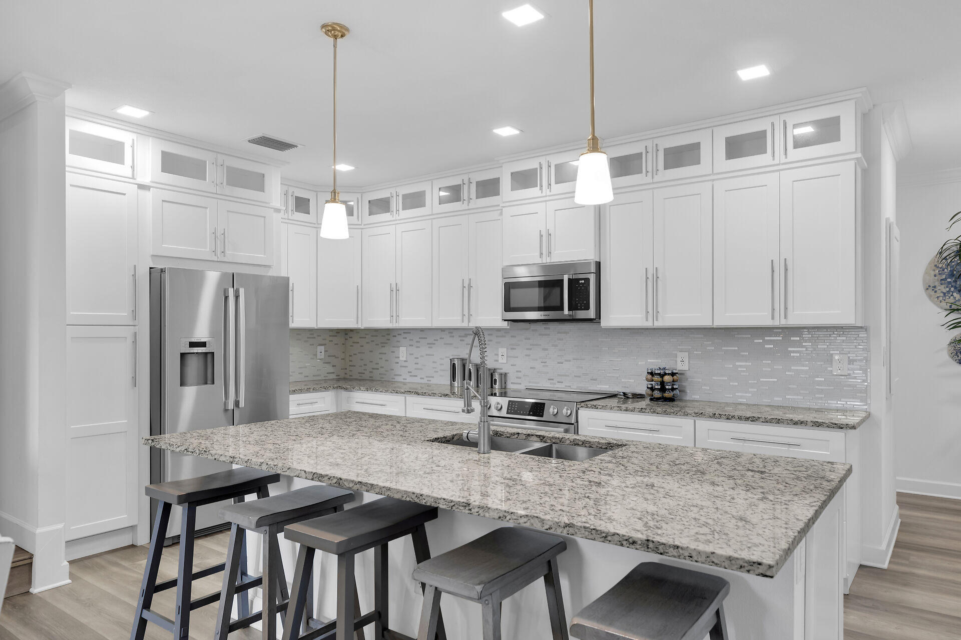 451 Sombrero Beach Road Marathon, FL 33050 - Photo 12 of 55 a kitchen with stainless steel appliances granite countertop a sink a microwave a refrigerator and white cabinets