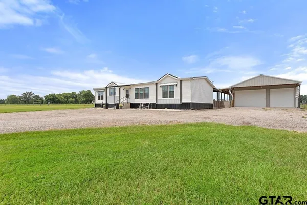 a front view of a house with a yard and lake view