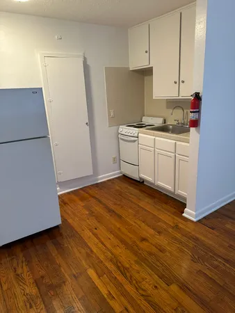 a kitchen with wooden floors and white appliances
