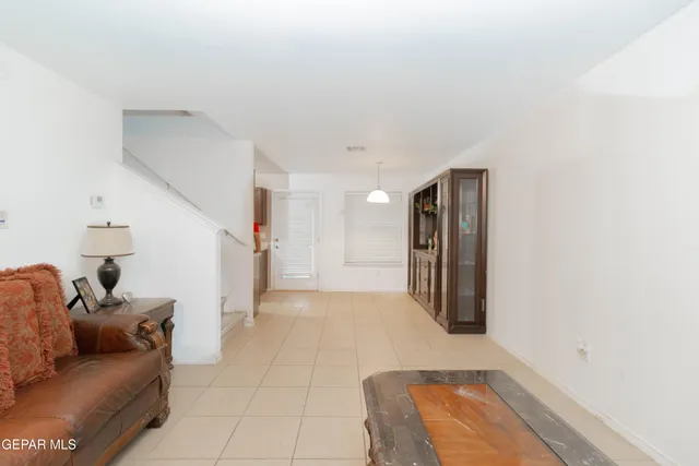 a view of a refrigerator in kitchen and an empty room