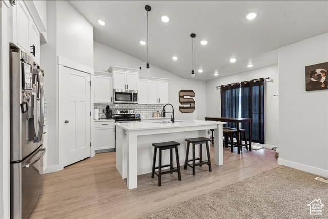 464 South Trejo Rdg Road Grantsville, UT 84029 - Photo 8 of 33 Kitchen featuring appliances with stainless steel finishes, a sink, baseboards, a kitchen breakfast bar, and white cabinetry