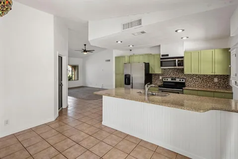 a large white kitchen with a large window and stainless steel appliances