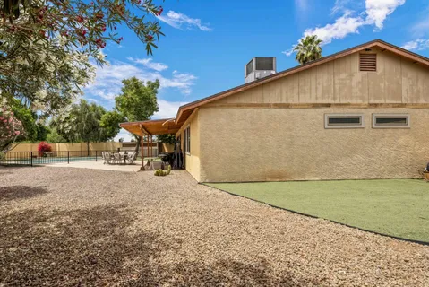 a backyard of a house with table and chairs