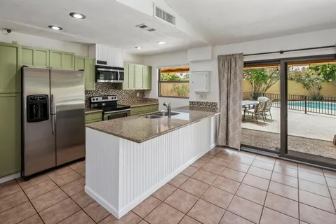 a kitchen with stainless steel appliances granite countertop a refrigerator and a sink