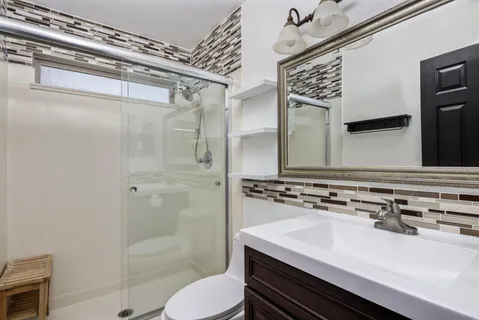 a bathroom with a sink a toilet and shower