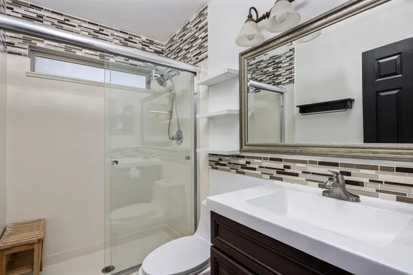 a bathroom with a sink a toilet and shower