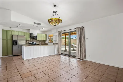 a view of kitchen with stainless steel appliances granite countertop a refrigerator and microwave