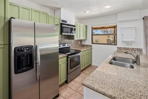 a kitchen with stainless steel appliances granite countertop a stove a refrigerator and a sink