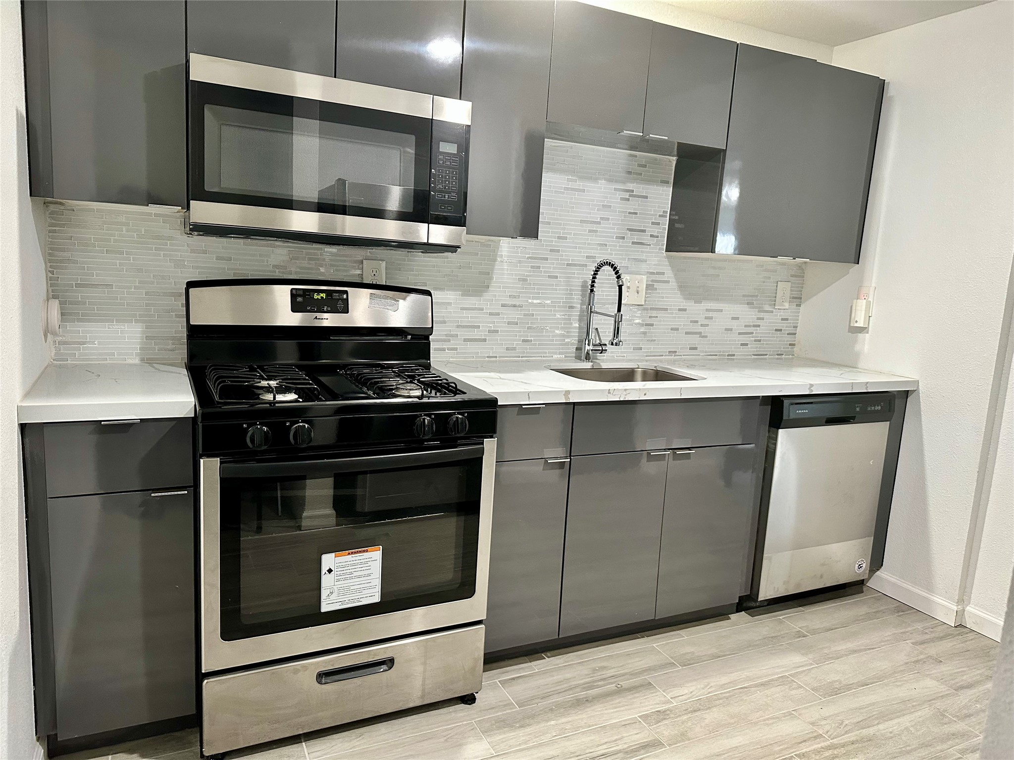 4802 Elser Street Houston, TX 77009 - Photo 12 of 21 a kitchen with stainless steel appliances a stove microwave and sink