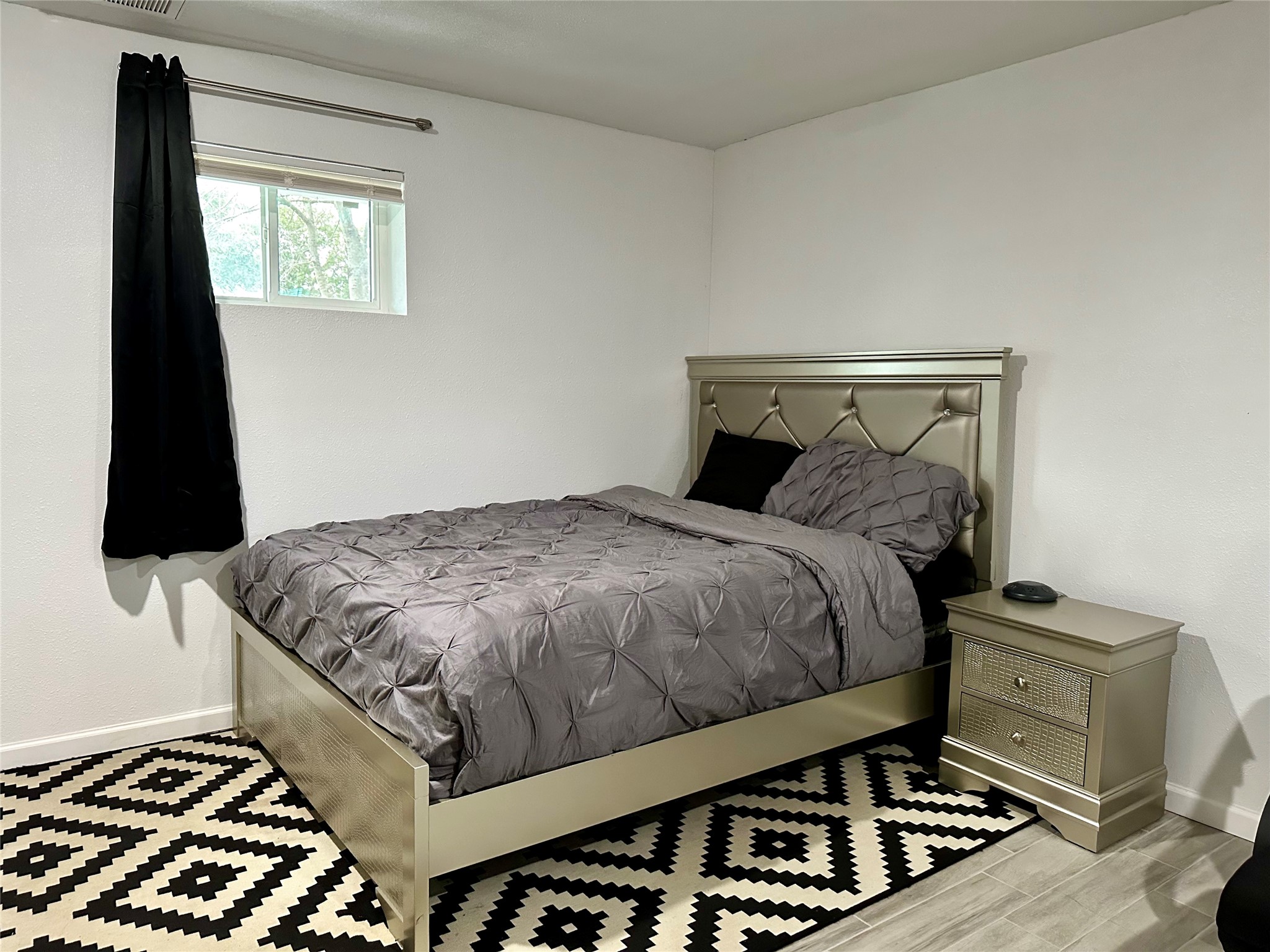 4802 Elser Street Houston, TX 77009 - Photo 9 of 21 a bedroom with a bed and a flat tv screen on a dresser