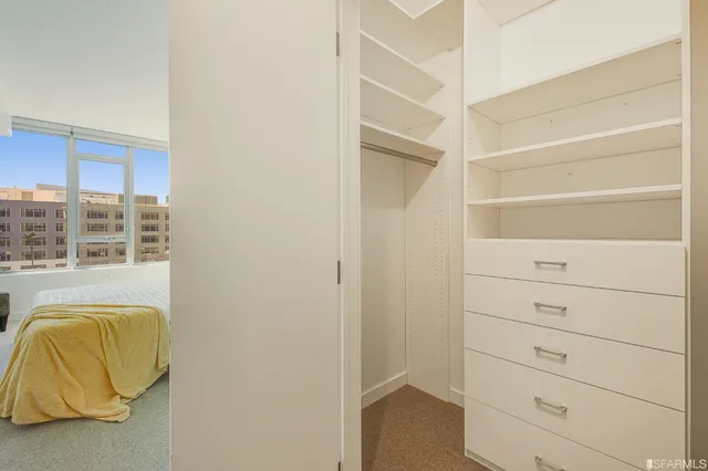 a view of walk in closet with clothes and shoes