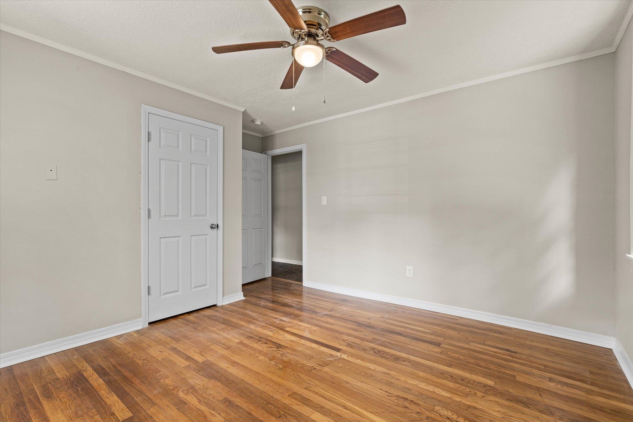 4700 Bit And Spur Road Mobile, AL 36608 - Photo 17 of 21 Unfurnished bedroom with baseboards, ornamental molding, and wood finished floors