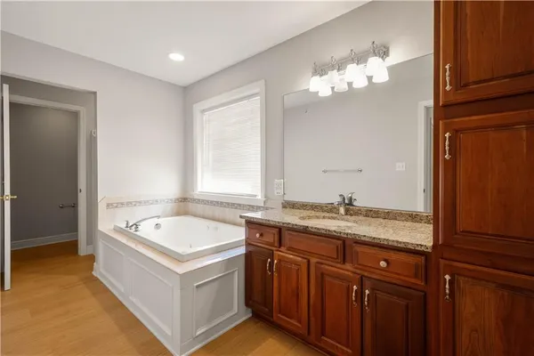 a bathroom with a tub a sink and a mirror