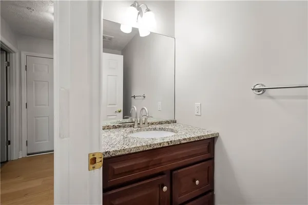 a bathroom with a granite countertop sink and a mirror