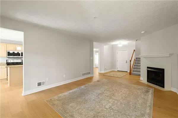 a view of empty room with wooden floor and fireplace