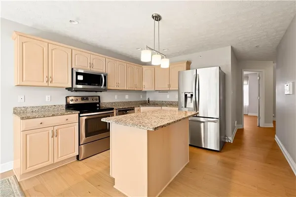 a kitchen with stainless steel appliances granite countertop a refrigerator stove microwave and sink