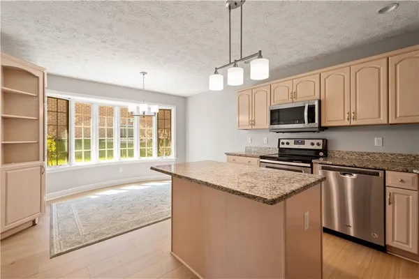 a kitchen with stainless steel appliances granite countertop a stove a sink and a granite counter tops