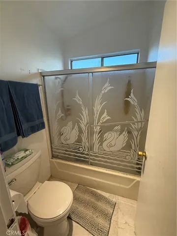 a bathroom with a toilet and a shower curtain
