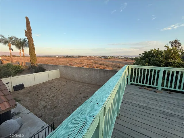a view of balcony with wooden floor and fence