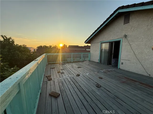 a view of deck with wooden floor and fence with a bench