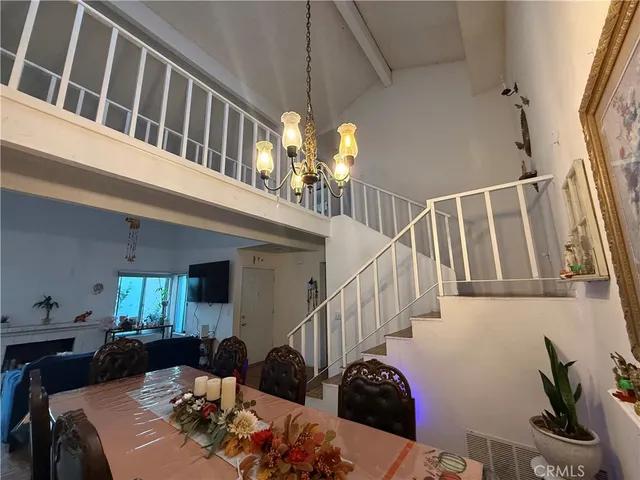 a view of a livingroom with furniture stairs wooden floor and windows