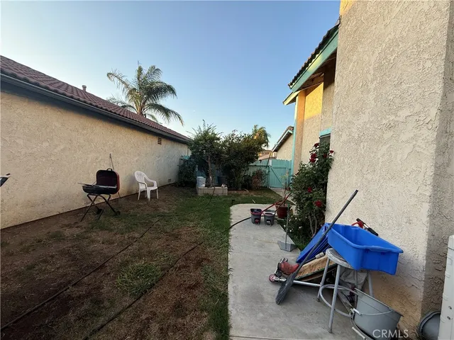 a backyard of a house with table and chairs