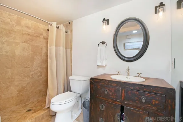 a bathroom with a toilet sink vanity and mirror