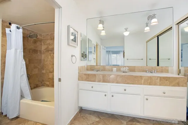 a bathroom with a tub sink and mirror