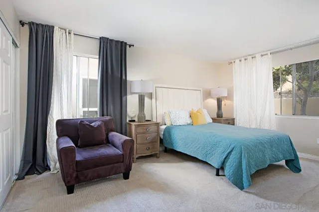 a bedroom with a bed and a couch next to a window