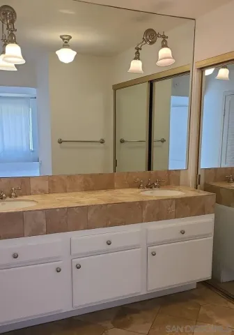 a bathroom with a sink vanity and mirror
