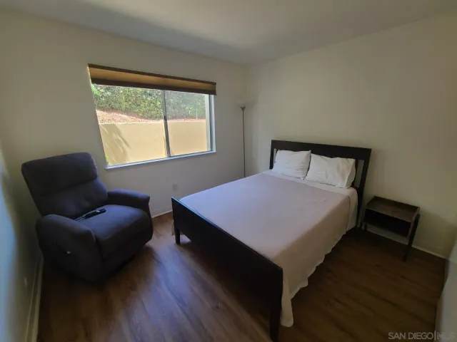 a bedroom with a bed chair and a window