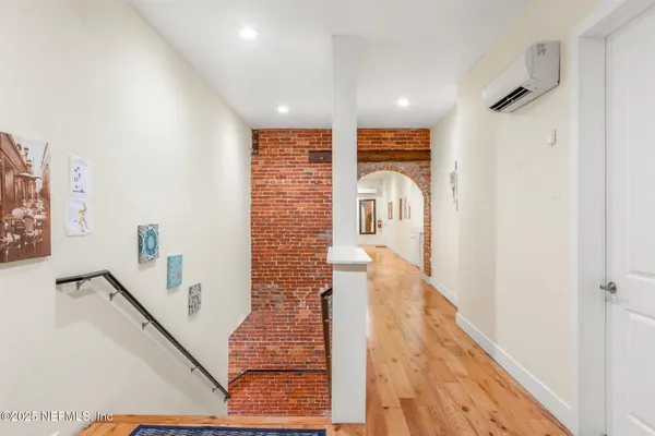 a view of hallway with wooden floor and stairs