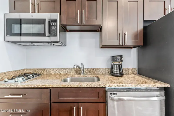 a kitchen with granite countertop a sink stove and cabinets