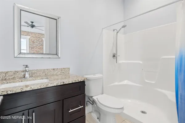 a bathroom with a granite countertop sink toilet and shower