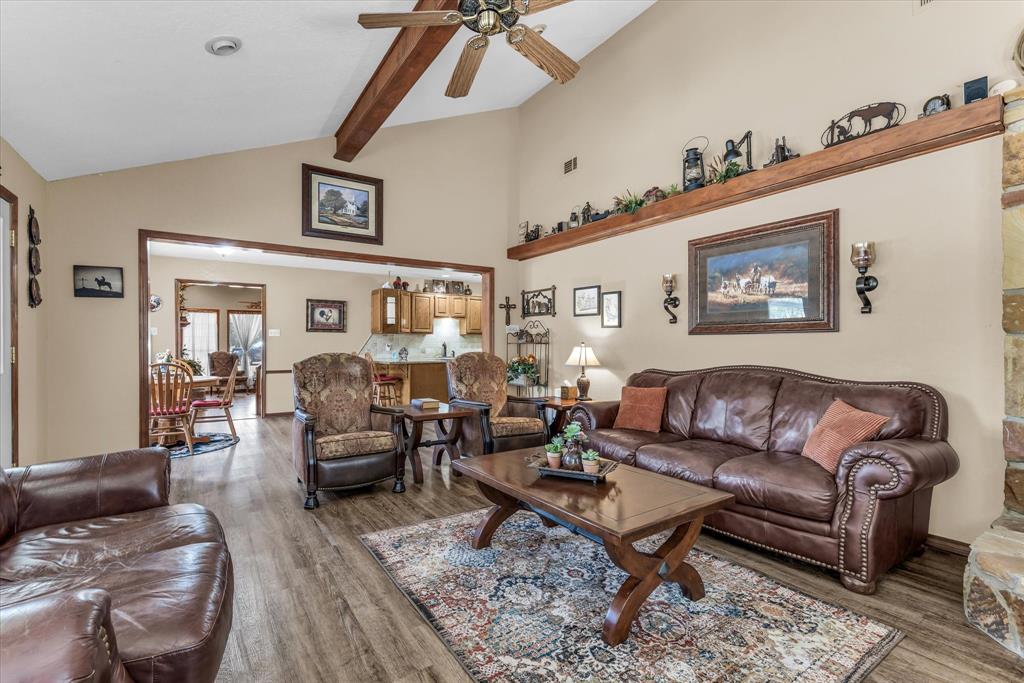 1438 Bend Of The Bosque Road China Spring, TX 76633 - Photo 16 of 33 Vaulted ceiling with exposed wood beams, wood-finish flooring, recessed lighting, and a stone-clad fireplace surround