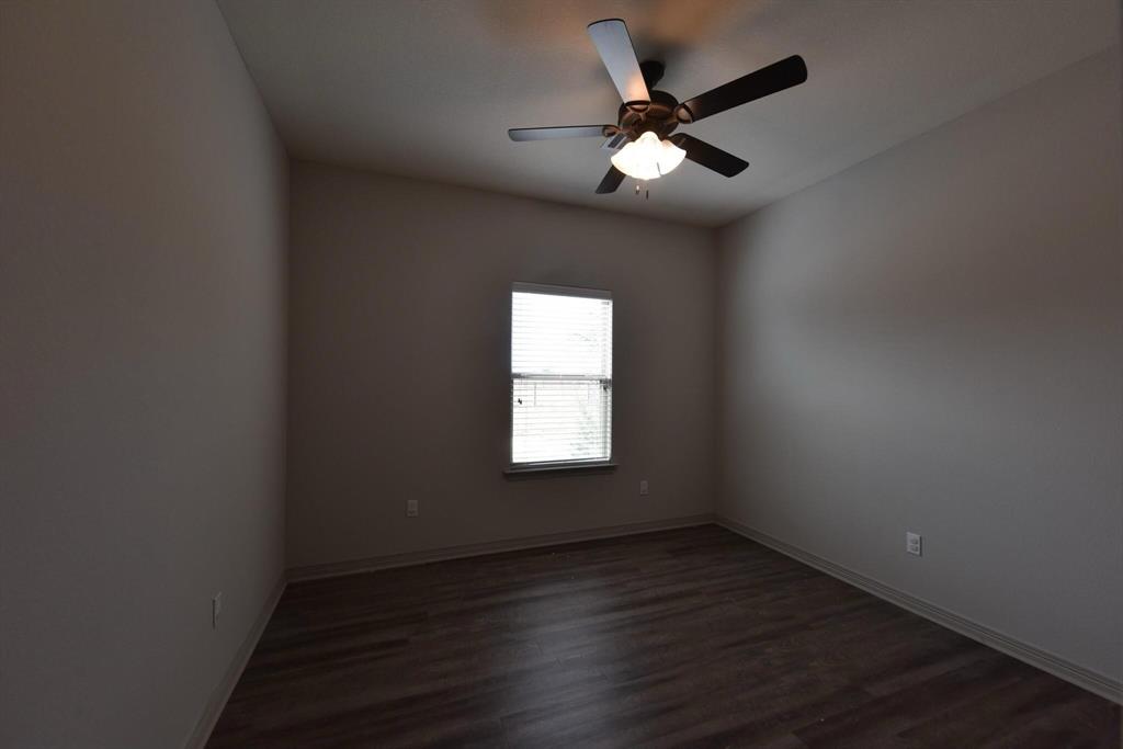 101 Capps Street, Unit A Rio Vista, TX 76093 - Photo 9 of 17 an empty room with wooden floor and windows