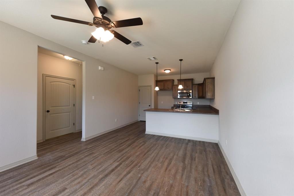 101 Capps Street, Unit A Rio Vista, TX 76093 - Photo 16 of 17 a room with kitchen island a wooden floor and ceiling fan