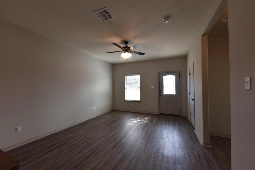 101 Capps Street, Unit A Rio Vista, TX 76093 - Photo 5 of 17 wooden floor in an empty room with a window
