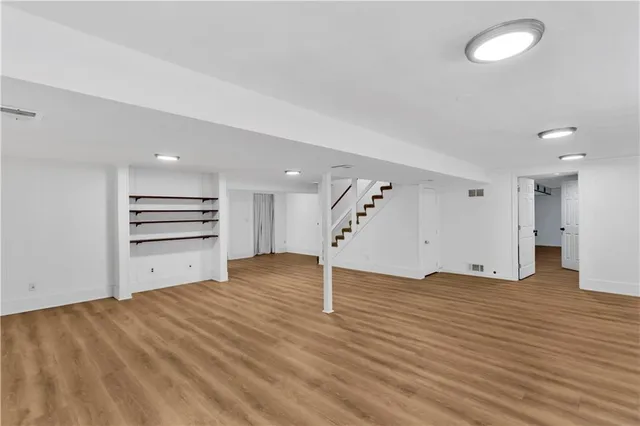 a view of empty room with wooden floor and window