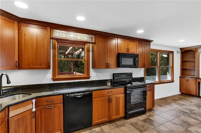 a kitchen with stainless steel appliances granite countertop a stove a sink and a microwave