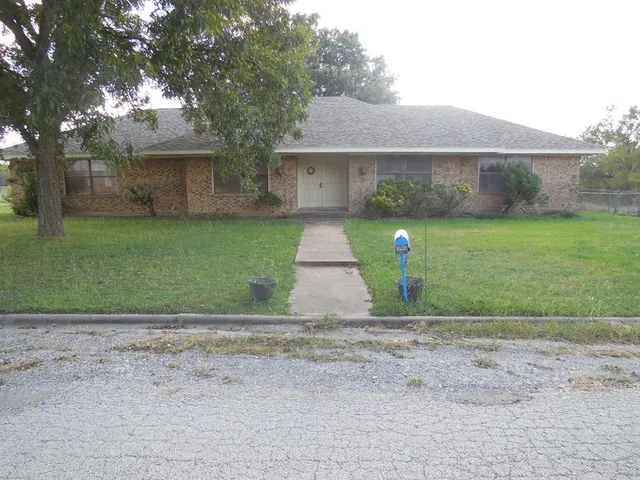 a front view of a house with a yard and a garden