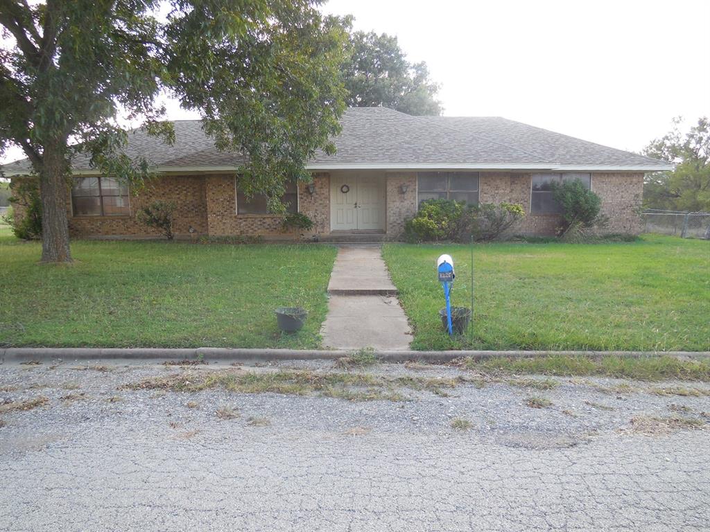 a front view of a house with a yard and a garden