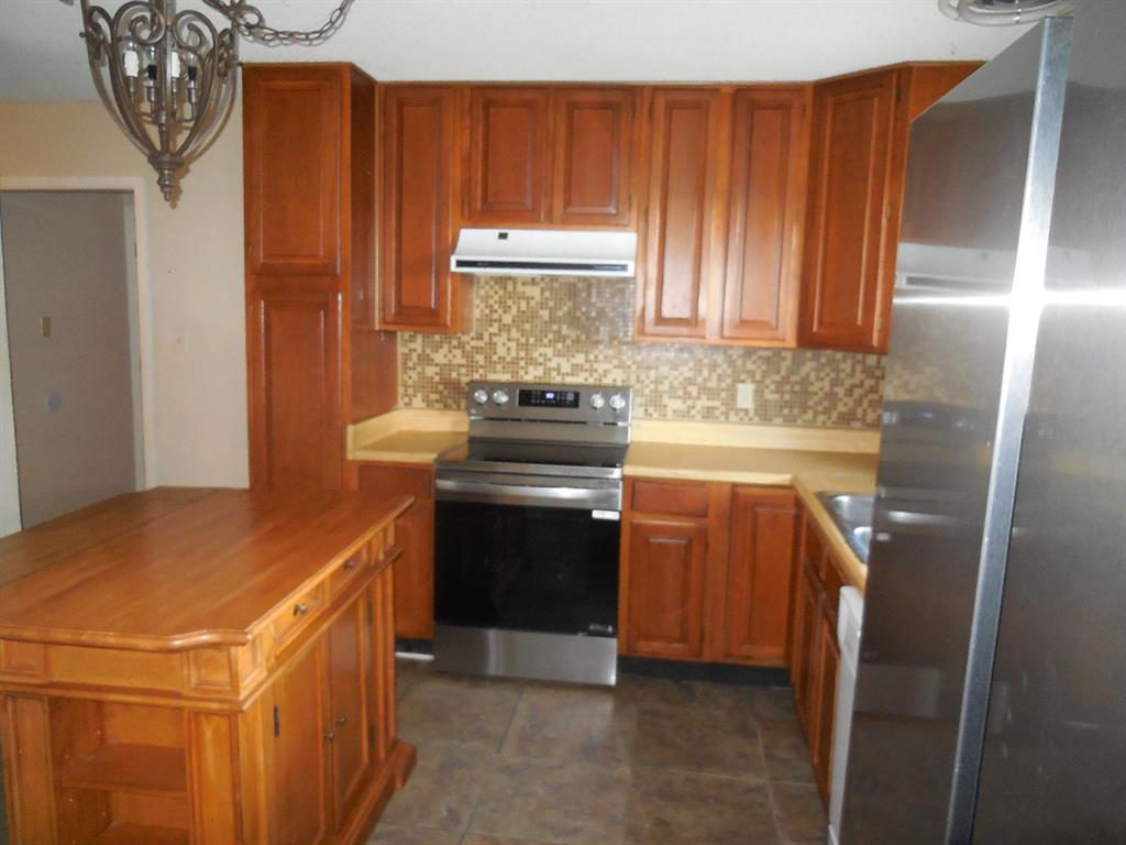 1220 Meadowbrook Street Ranger, TX 76470 - Photo 7 of 28 a kitchen with stainless steel appliances granite countertop a stove a refrigerator and a oven